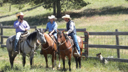 Kara Creek Ranch three cowboys sitting on horses in field with dog