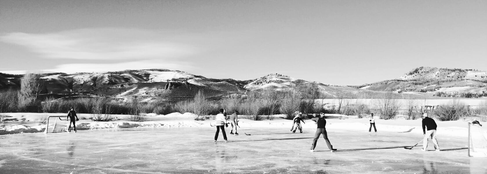 Old photo of people playing hockey on a frozen pond