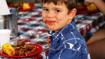 Young boy eating BBQ dinner at Cherokee Park Ranch
