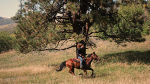 Cowgirl loping at Colorado Trails Ranch