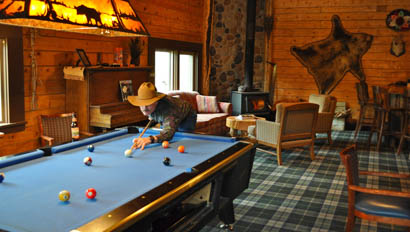 Guest playing pool at Crossed Sabres Ranch