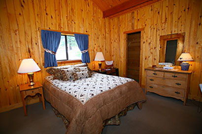 Elk Mountain Ranch Cabin with wood walls and western bed