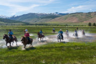 Hunewill Ranch riders splashing through water on horses