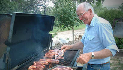 Man grilling food on a grill at Klondike Ranch