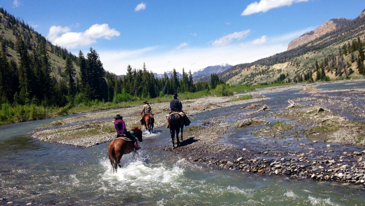 Riders crossing a creek at Lazy L&B Ranch
