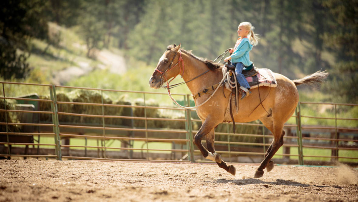 Kid loping in an arena at Lost Valley Ranch