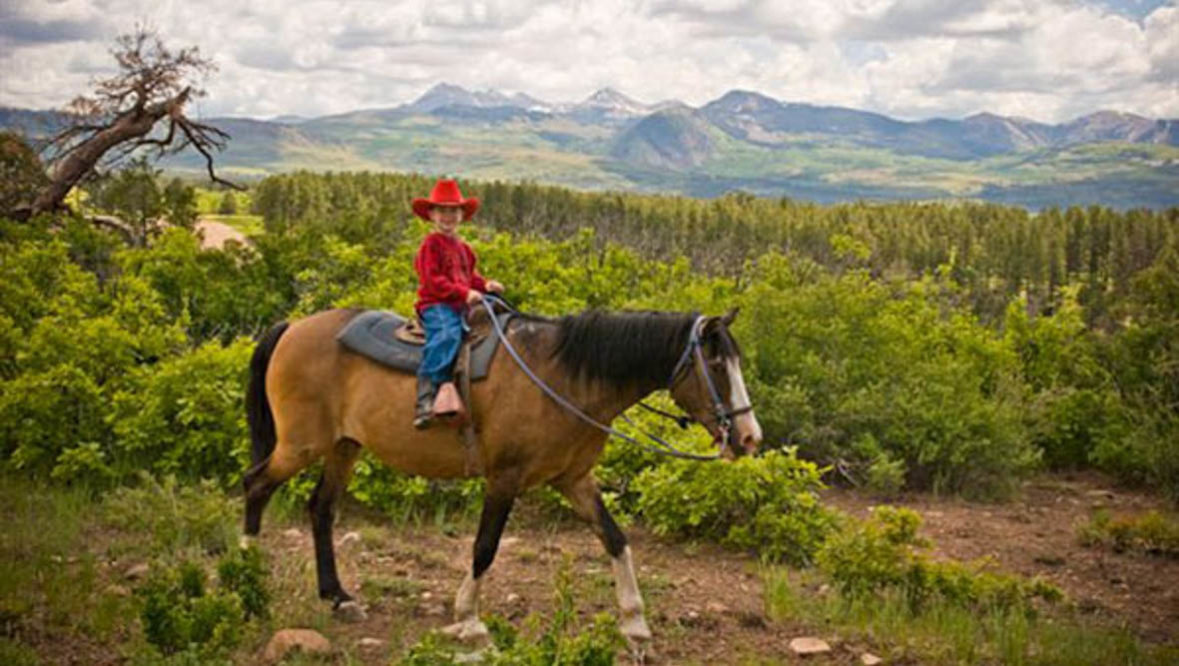 Kid cowboy on horse at Majestic Dude Ranch