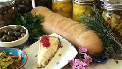 Cheese cake, bread, and other foods spread on a table at Marble Mountain Ranch