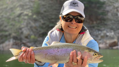 Woman holding up a caught fish at Medicine Bow Lodge