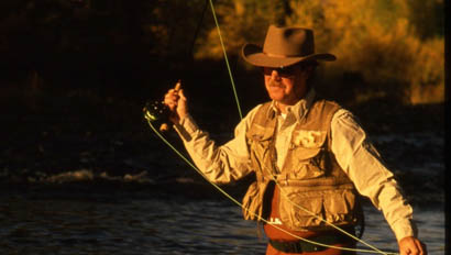 Man fly fishing in a river at Nine Quarter Circle Ranch