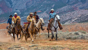 Group of riders loping at Hideout Lodge Ranch