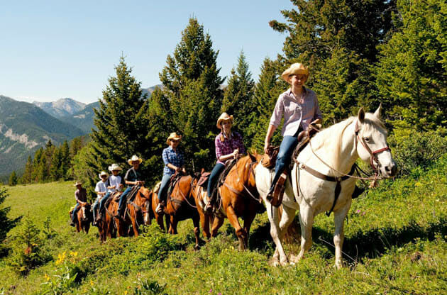 Group of people riding horses in a line