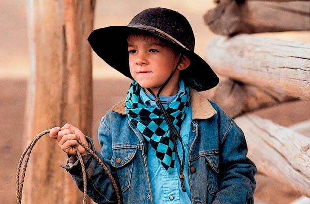 Young cowboy with a hat and lasso