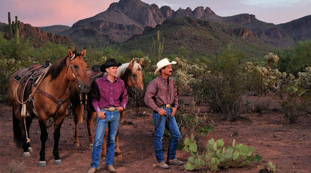 Two wranglers with their horses looking at the view