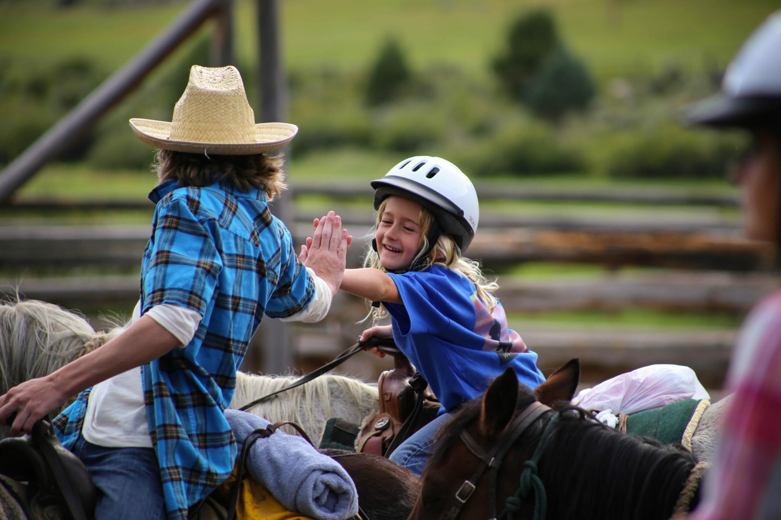 kids high fiving at a dude ranch
