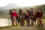 Riders standing next to their horses