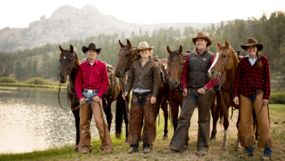 Riders standing next to their horses