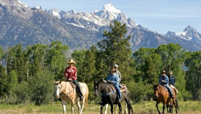 Family on a trail ride with mountains in the background