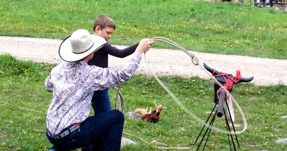 cowboy and little boy roping a fake cow head