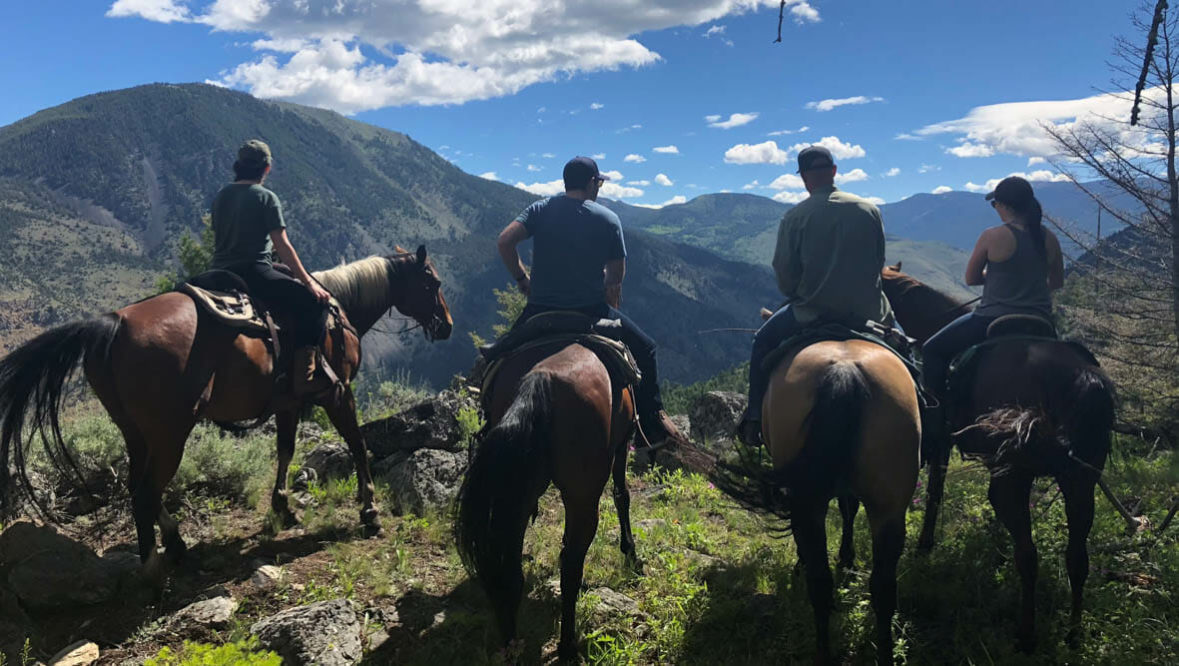 Cowboys on horses looking at the view at Hubbards Ranch