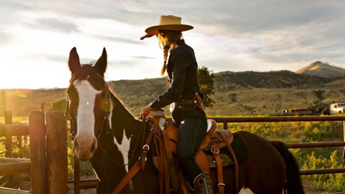 Cowgirl on a horse at sunset at Mountain Sky Guest Ranch
