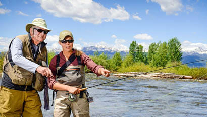 Two guests fishing in a river at Parade Rest Ranch