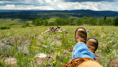 Person laying in a field at Rainbow Trout Ranch