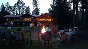 Guests dining around camp fire at Rich's Montana Guest Ranch