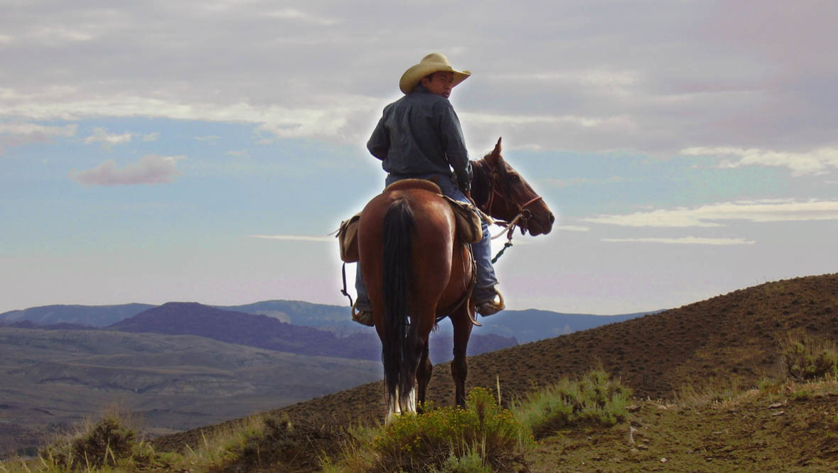 Teenager on a horse looking at an amazing view at Rimrock Dude Ranch