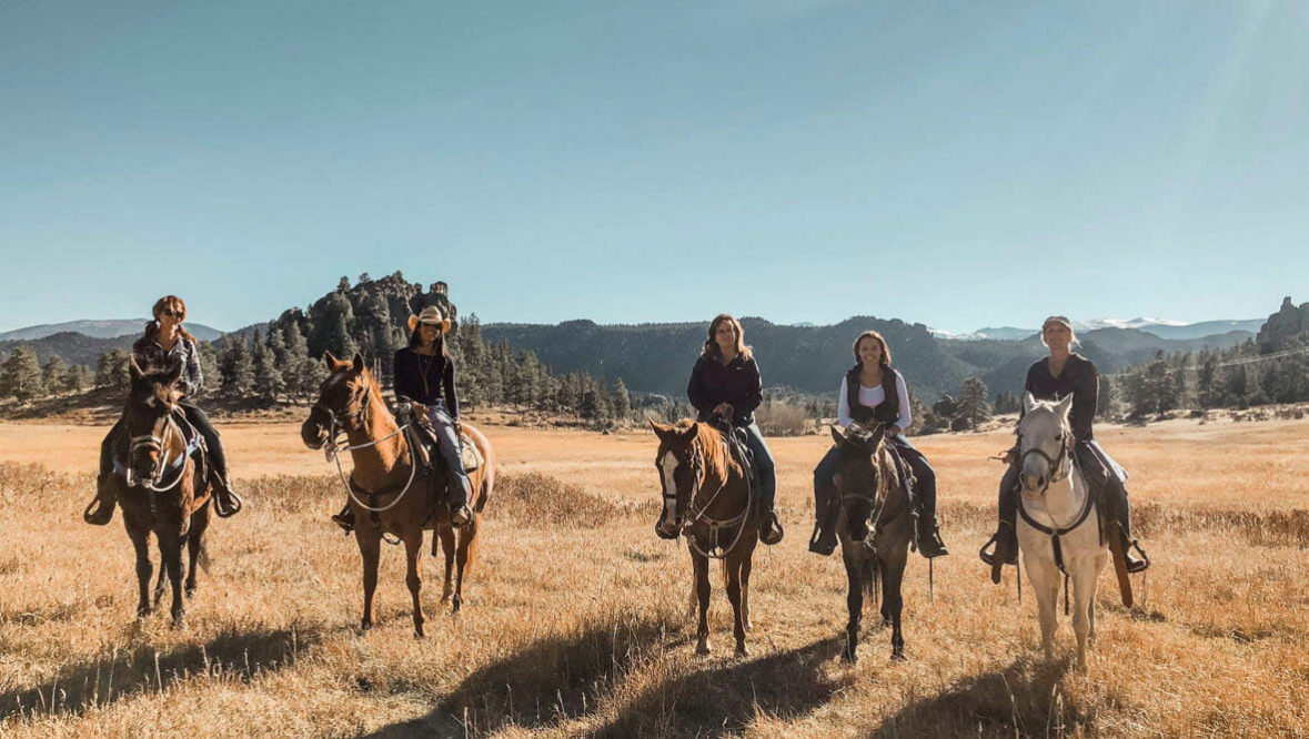 Sundance Trail Ranch guests on horses in a field