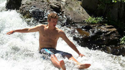 Sweet Grass Ranch teenager sliding down a creek