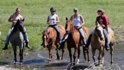 teen riders crossing a stream